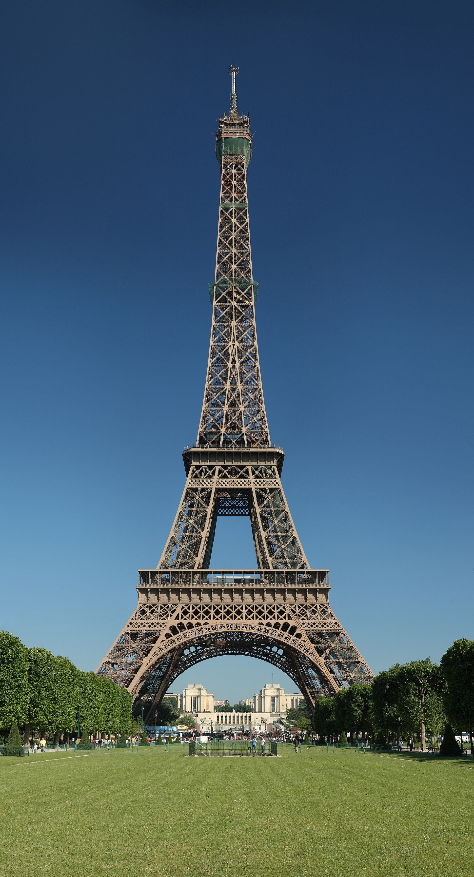 Torre Eiffel vista do Champ de Mars sob céu azul, em Paris